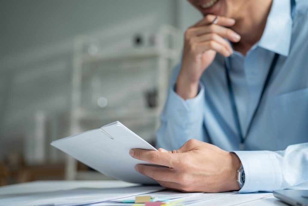 A commercial banker reading through a printed credit paper at his desk