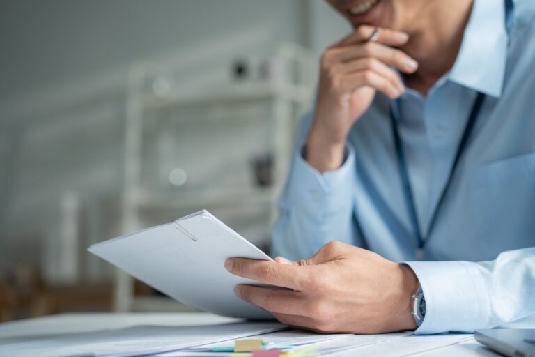 A commercial banker reading through a printed credit paper at his desk